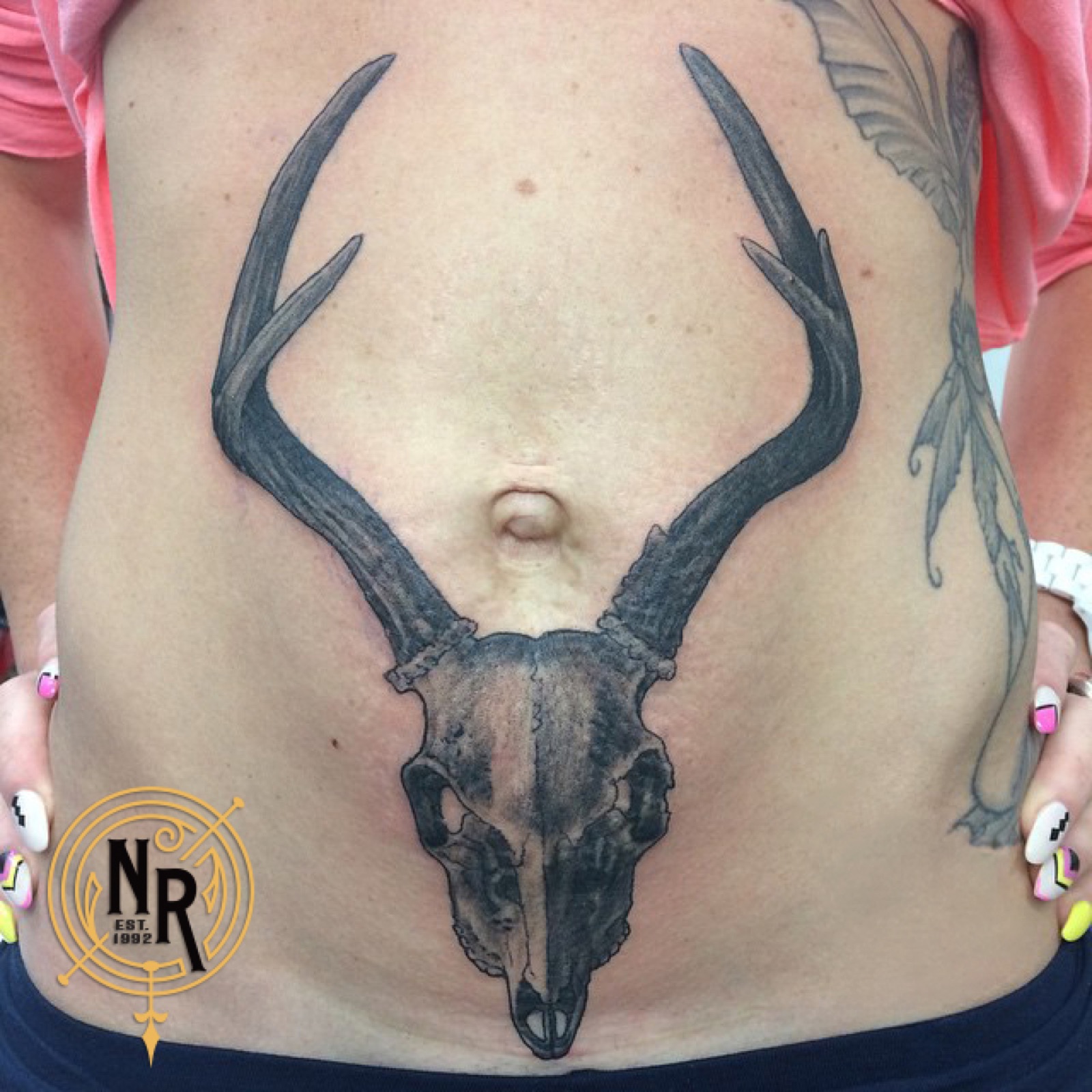 Deer skull tattoo across stomach
